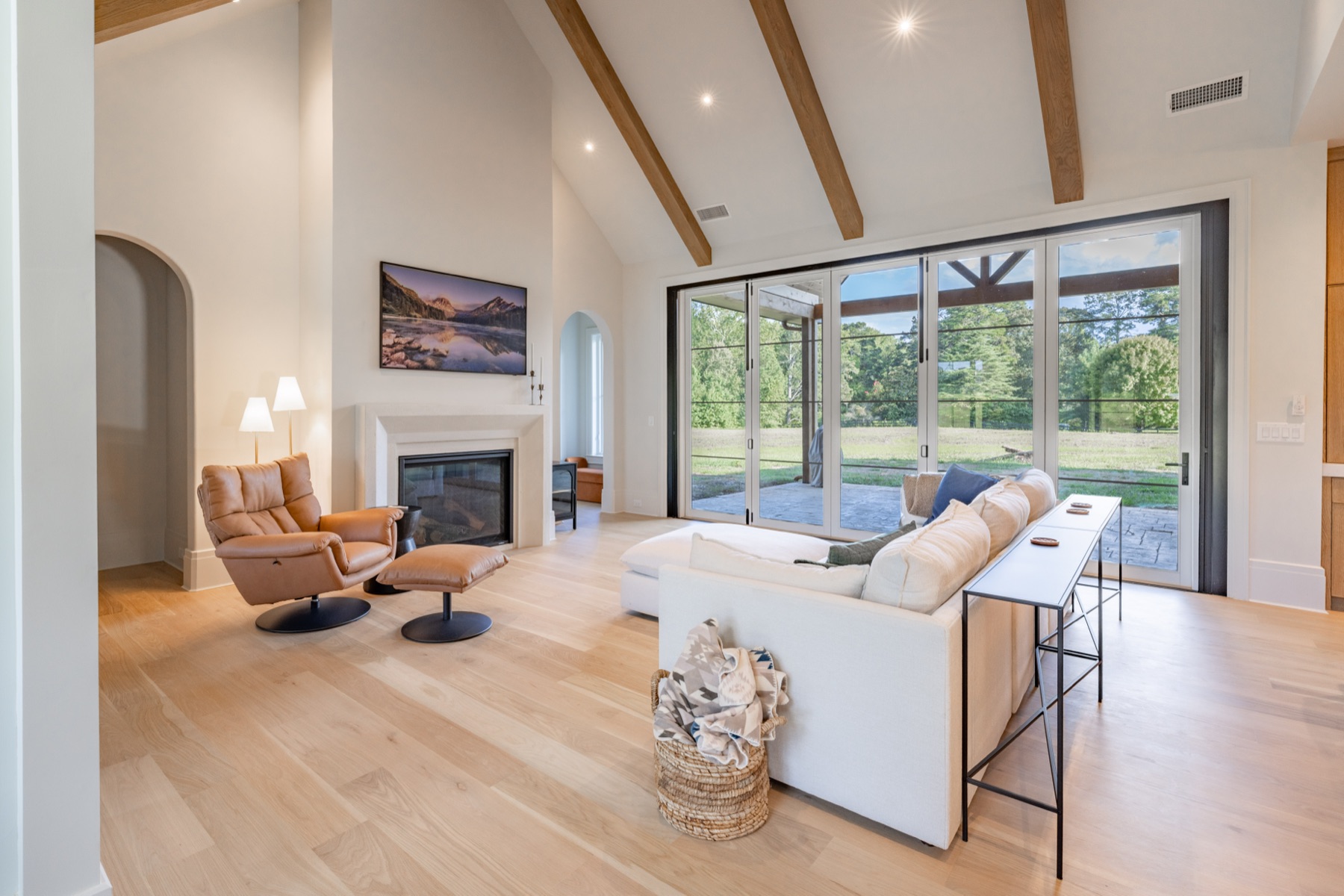 Vaulted living room with beams and a wall of glass