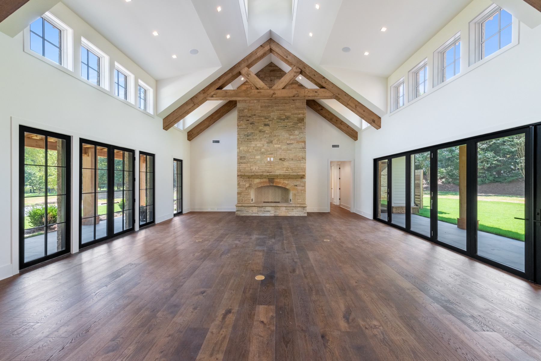 Vaulted great room with timber trusses and a stone fireplace