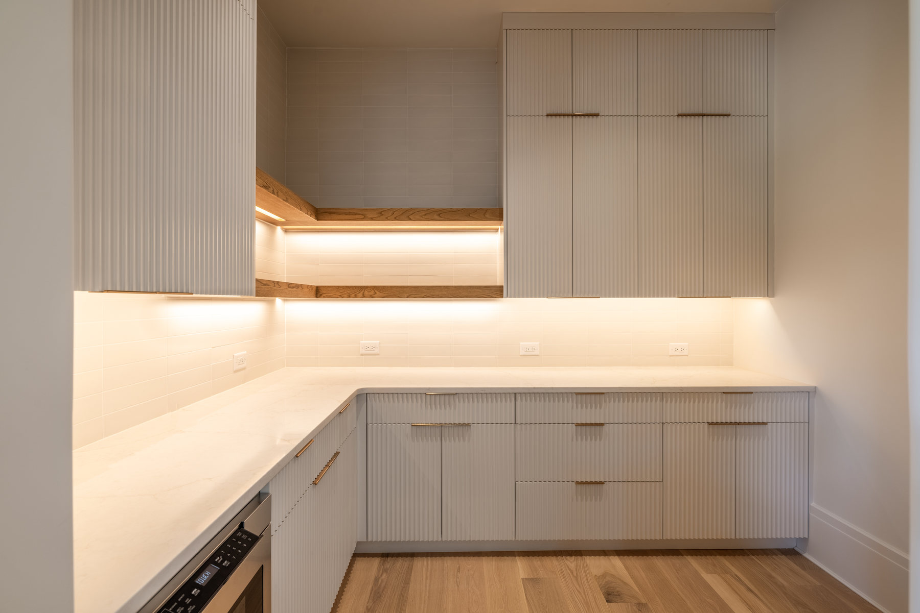 Kitchen with fluted cabinetry and brass hardware