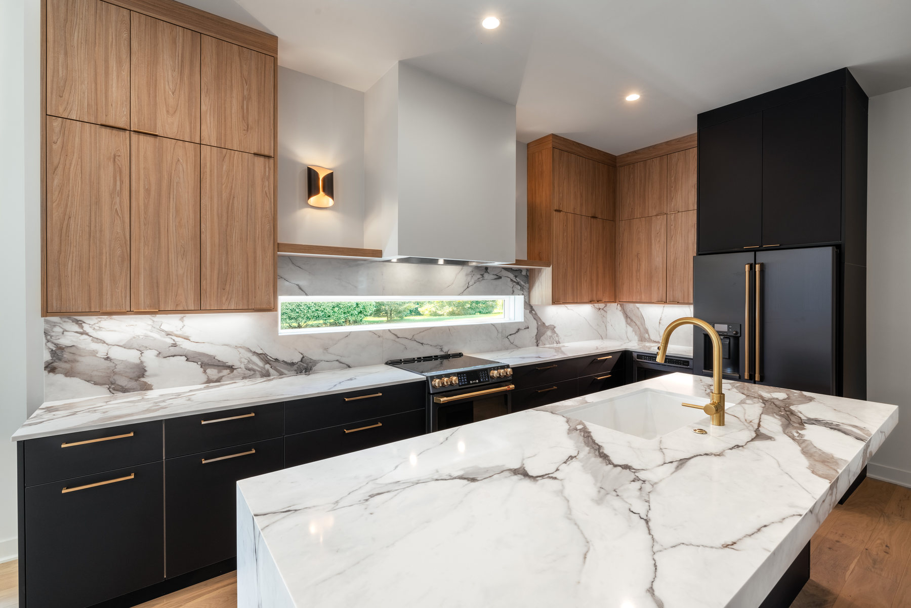 Kitchen island with marble waterfall countertop and brass fixtures